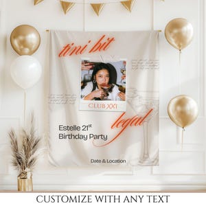 May include: A custom banner for a 21st birthday party. The banner features a photo of a person drinking a cocktail, with the words "tini bit" and "legal" in red script. Gold and white balloons and a gold banner are also visible.