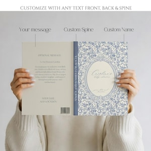 May include: A custom baby shower guest book with a blue floral design on the cover. The book's spine reads "ADVICE AND WISHES FOR ALICIA." The front cover features the text "Caroline's baby shower" within an oval frame. The book is customizable with text.