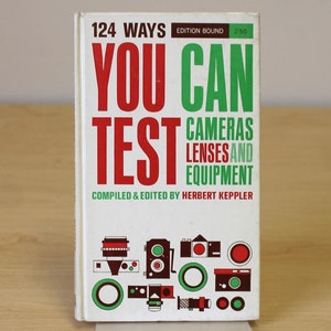 May include: A white book with a red and green title that reads "124 Ways You Can Test Cameras Lenses and Equipment" by Herbert Keppler. The cover features illustrations of cameras and lenses.