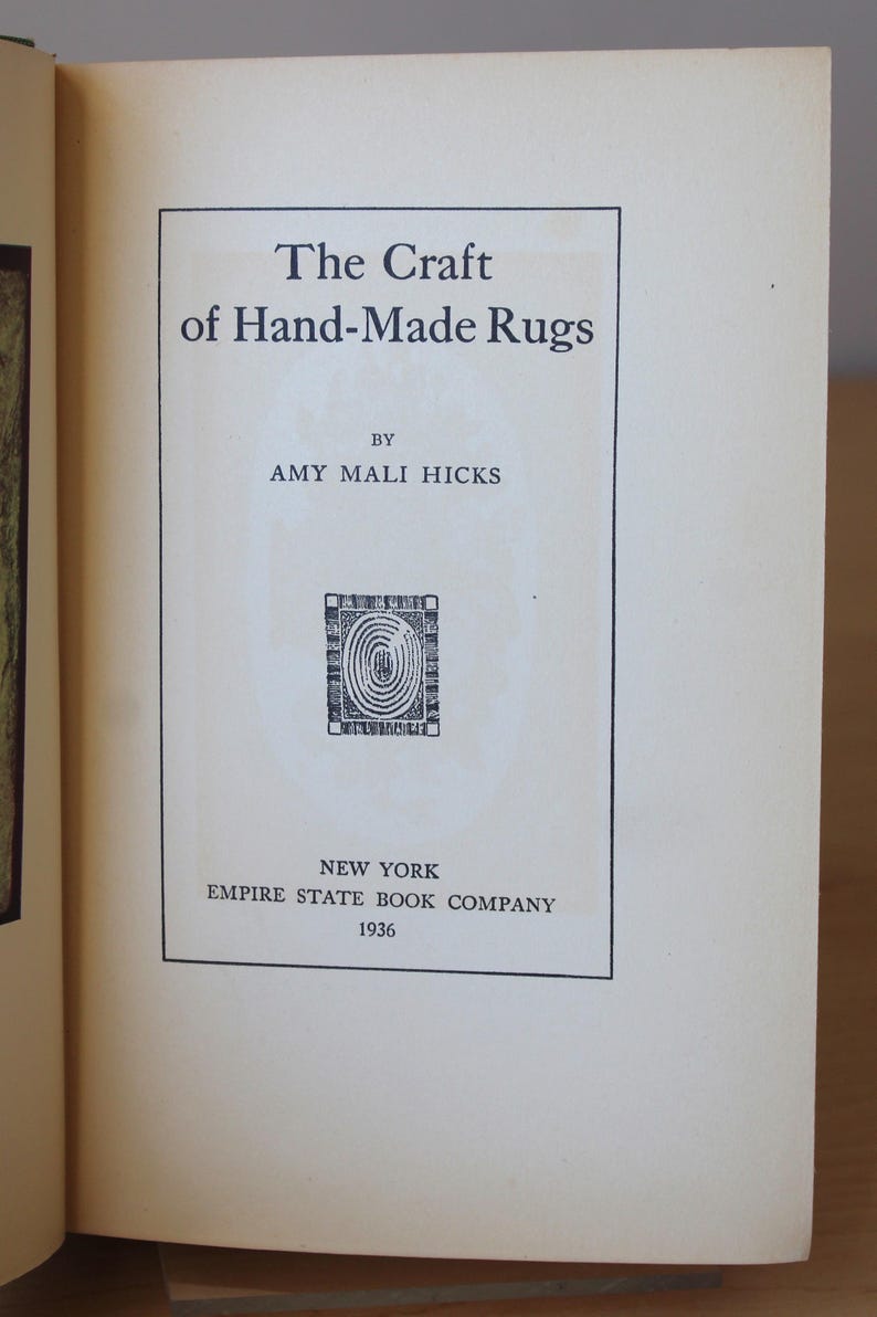 May include: The cover of a book titled "The Craft of Hand-Made Rugs" by Amy Mali Hicks. The book was published in 1936 by the Empire State Book Company in New York.