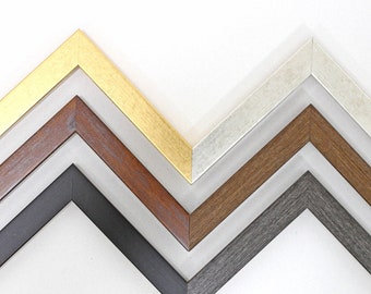 May include: Four picture frames in different colors and finishes: gold, brown, gray, and white. The frames are arranged in a staggered pattern, with the gold frame at the top and the white frame at the bottom.