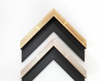 May include: Two picture frames with black matting and different colored wood frames. The top frame is a light wood with gold accents. The bottom frame is a light wood with silver accents.