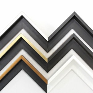 May include: Four picture frames in different colors and styles. The frames are arranged in a zig-zag pattern, with the largest frame at the bottom and the smallest frame at the top. The frames are all made of wood and have a simple, modern design.