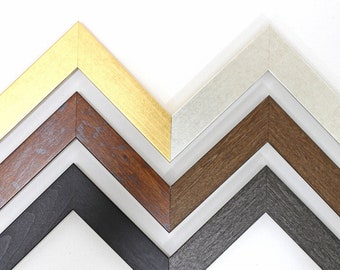 May include: Five picture frames in different colors and finishes. The frames are arranged in a staggered pattern, with the top frame being gold, the second frame being white, the third frame being brown, the fourth frame being black, and the fifth frame being gray.