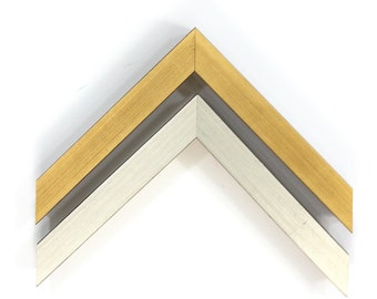 May include: Two picture frames, one gold and one silver, are stacked on top of each other. The frames are made of metal and have a simple, modern design.