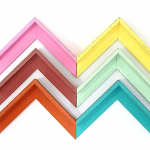 Puede incluir: Seis marcos de fotos de madera en varios colores, incluyendo rosa, rojo, naranja, verde, verde claro y amarillo. Los marcos están dispuestos en un patrón de chevron.