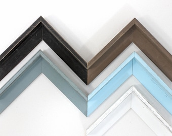 May include: Four picture frames in different colors, stacked on top of each other. The top frame is black, the second frame is brown, the third frame is light blue, and the bottom frame is white.