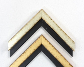 May include: Two picture frames with black, gold, and white painted edges. The frames are stacked on top of each other.