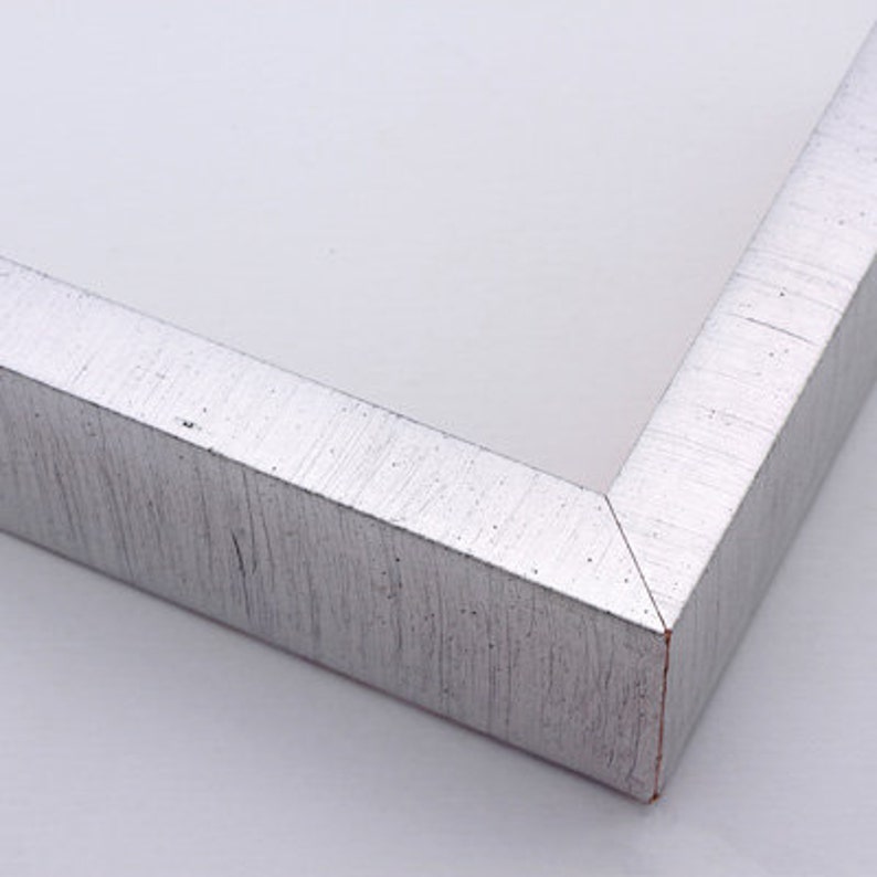 May include: Close-up of a silver picture frame with a textured finish. The frame has a beveled edge and a subtle sheen.