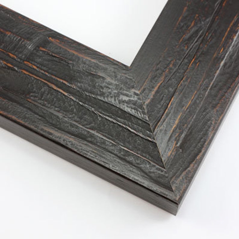 May include: Close-up of a corner of a dark gray wooden picture frame. The frame has a distressed, textured appearance with visible wood grain and hints of brown. The frame is angled, showing the corner joint and the inner edge.