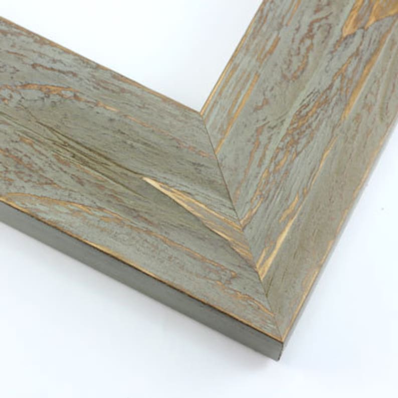 May include: Close-up of a corner of a wooden picture frame. The frame has a distressed, weathered appearance with a gray-blue finish and visible wood grain. The edges are dark brown.