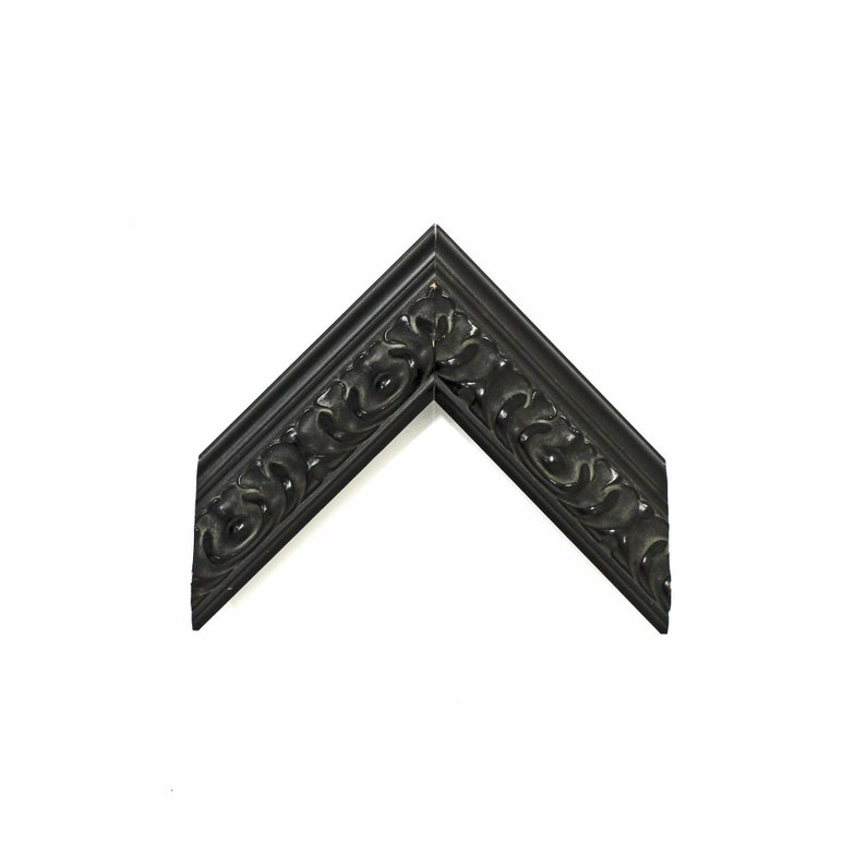 May include: Black ornate picture frame with a decorative, carved design. The frame is made of wood and has a matte finish.