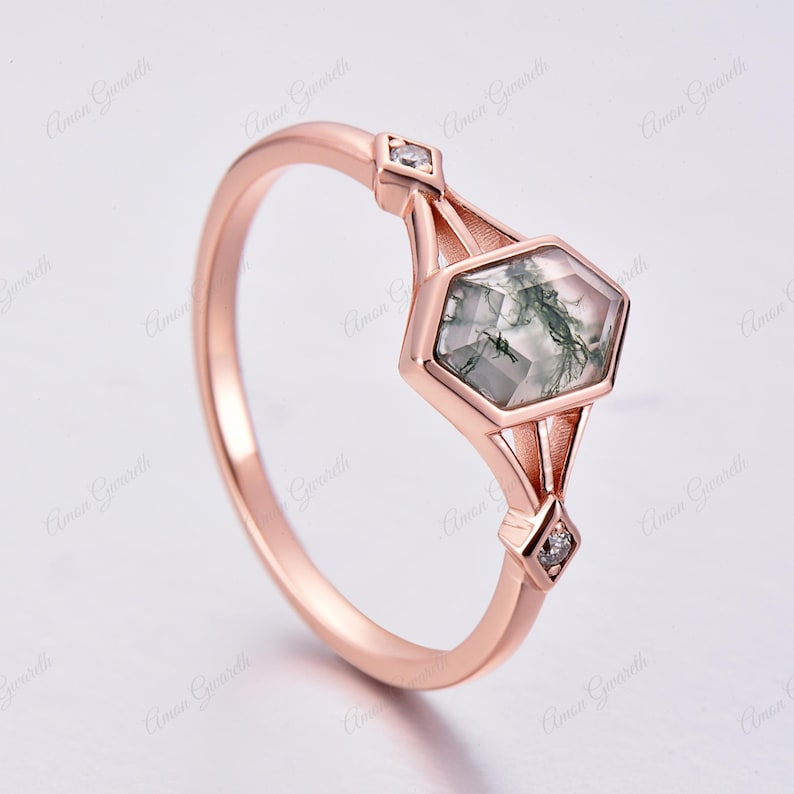 Puede incluir: Un anillo de oro rosa con una piedra hexagonal de &aacute;gata verde musgo y dos peque&ntilde;os diamantes. El anillo tiene un dise&ntilde;o geom&eacute;trico.