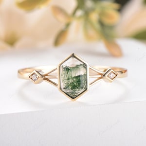 Puede incluir: Un anillo de oro con una piedra hexagonal de &aacute;gata verde musgo y dos peque&ntilde;os diamantes en la banda.