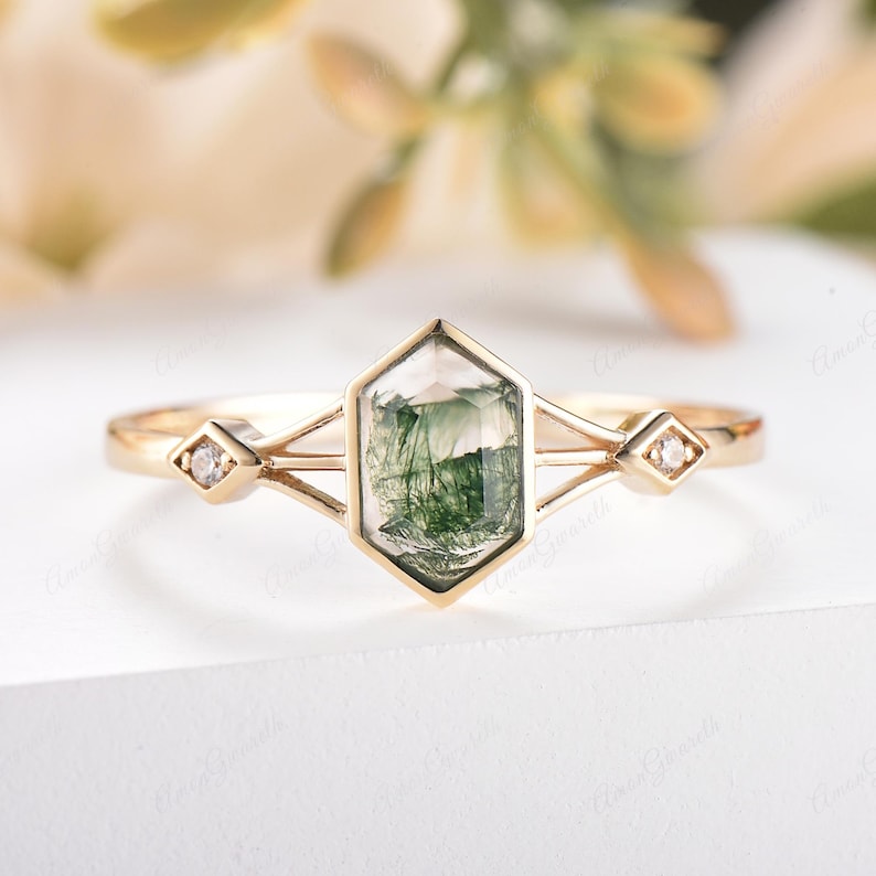Puede incluir: Un anillo de oro con una piedra hexagonal de &aacute;gata verde musgo y dos peque&ntilde;os diamantes en la banda.