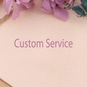 Könnte beinhalten: Nahaufnahme eines hellrosa strukturierten Papiers mit dem Text "Custom Service" in violetter Schrift.