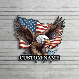 Könnte beinhalten: Ein patriotisches Design mit einem Weißkopfseeadler mit ausgebreiteten Flügeln vor einer wehenden amerikanischen Flagge. Der Adler ist braun und weiß mit einem gelben Schnabel. Darunter befindet sich eine Karte der Vereinigten Staaten mit dem Text "CUSTOM NAME".