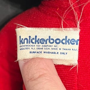 May include: A white tag with blue text that reads "knickerbocker" and "KNICKERBOCKER TOY COMPANY INC, MIDDLESEX. N.J. 08846 USA. MADE IN TAIWAN ROC SURFACE WASHABLE ONLY".