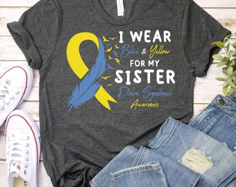 May include: Gray t-shirt with a blue and yellow ribbon, a blue feather, and the text "I wear blue & yellow for my sister Down Syndrome Awareness".