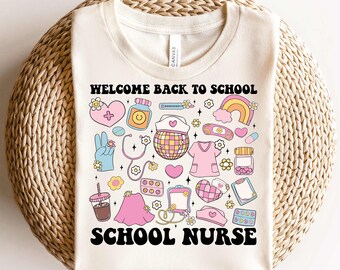 May include: A cream-colored t-shirt featuring the black text Welcome Back To School School Nurse. The graphic includes colorful illustrations of a disco ball, stethoscope, medical scrubs, pills, a rainbow, a heart, and a coffee cup in pastel tones.