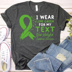 May include: A dark grey t-shirt with a lime green ribbon and the text "I wear lime green for my TEXT Non-Hodgkin Lymphoma Awareness".