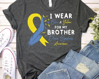 May include: A dark grey t-shirt with a blue and yellow ribbon, a blue feather, and the text "I wear blue & yellow for my brother Down Syndrome Awareness".