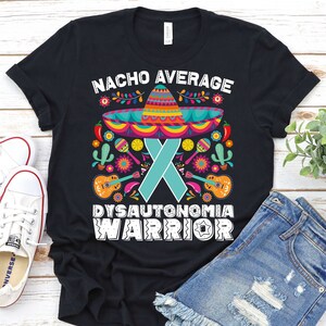 May include: Black t-shirt with a white graphic design featuring a sombrero, a turquoise ribbon, and the text "Nacho Average Dysautonomia Warrior".