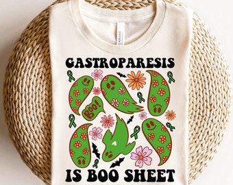 May include: A white t-shirt with a green, orange, and pink design of ghosts, bats, and flowers. The text "Gastroparesis is Boo Sheet" is printed in black on the shirt.