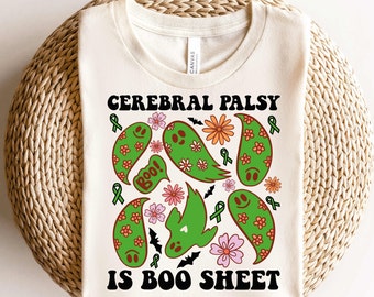 May include: A white t-shirt with a green, orange, and pink design of ghosts, bats, and flowers. The text "Cerebral Palsy is Boo Sheet" is printed in black on the shirt.