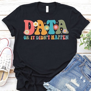 May include: Black t-shirt with a retro-style graphic that says "DATA OR IT DIDN'T HAPPEN" in colorful letters with flowers and smiley faces.