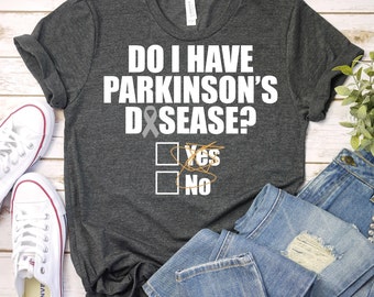 May include: A dark grey t-shirt with the text "Do I have Parkinson's Disease?" with a check box next to "Yes" crossed out and a check box next to "No" selected. A grey ribbon is next to the text "Disease".
