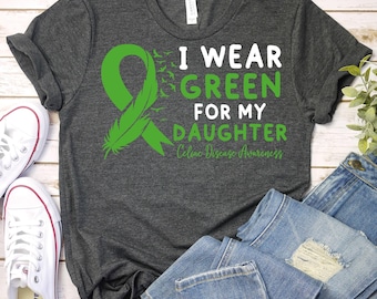 May include: A gray t-shirt with a green ribbon and the text "I wear green for my daughter Celiac Disease Awareness".