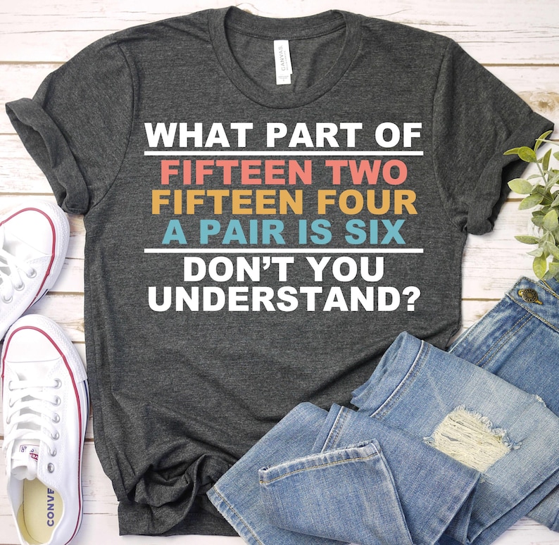 May include: A dark gray t-shirt with the text "WHAT PART OF FIFTEEN TWO FIFTEEN FOUR A PAIR IS SIX DON'T YOU UNDERSTAND?" printed in colorful letters.