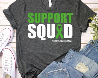 May include: A dark gray t-shirt with the text "SUPPORT SQUAD" in white letters with a green ribbon. The text "#CEREBRALPALSYAWARENESS" is printed in smaller letters below the ribbon.