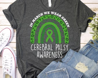 May include: A dark gray t-shirt with a green rainbow and a green ribbon. The text "In March We Wear Green Cerebral Palsy Awareness" is printed on the shirt.