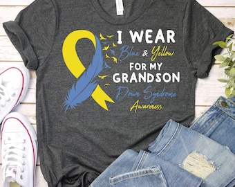 May include: A gray t-shirt with a blue and yellow ribbon, a feather, and the text "I wear blue & yellow for my grandson Down Syndrome Awareness".