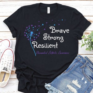 May include: Black t-shirt with a blue and purple dandelion graphic and the text "Brave Strong Resilient Rheumatoid Arthritis Awareness".