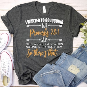 May include: A dark gray t-shirt with a white graphic print that says "I wanted to go jogging but Proverbs 28:1 says "The wicked run when no one is chasing them" So there's that."
