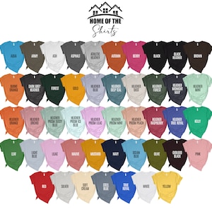 May include: A selection of t-shirts in a variety of colours, such as aqua, army green, ash, and black. The shirts are arranged in rows, displaying a wide range of shades. The text "HOME OF THE Shirts" is at the top.