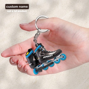 May include: Black and blue roller skate keychain with the word "MASON" on the side. The keychain is attached to a silver key ring.