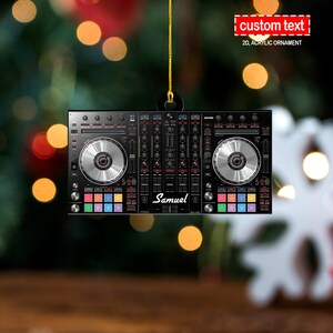 Pode incluir: Um misturador de DJ preto e vermelho com duas knobs prateadas e uma seção de pads coloridos. O misturador tem o texto "Samuel" impresso nele.