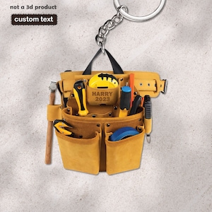 May include: A brown leather tool belt with a variety of tools, including a hammer, screwdriver, tape measure, and utility knife. The belt is personalized with the name "HARRY" and the year "2023".