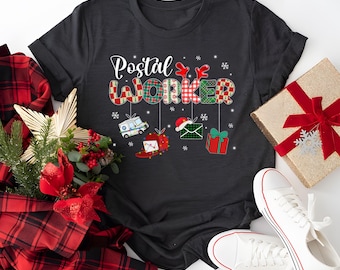 May include: A black t-shirt with a Christmas-themed design that says "Postal Worker". The design features a mail truck, a stocking, a letter, and a gift box.