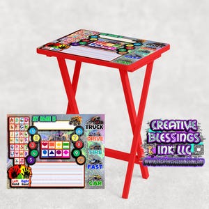 May include: Red folding table with a colorful monster truck themed tabletop. The tabletop has a learning chart with letters, numbers, and words like "truck", "drive", "tire", "fast", and "car".