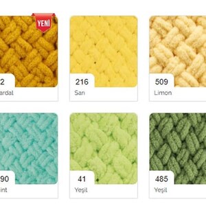 May include: A collection of yarn samples in various colors, including orange, yellow, green, blue, and black. The yarn is arranged in a grid pattern and labeled with numbers and color names in Turkish.