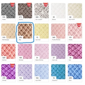 May include: A color chart of yarn samples in various shades of pink, beige, blue, and white. The yarn is a soft, fluffy texture and is arranged in a grid pattern. Each sample has a number and a name in Turkish.