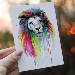 May include: A colorful watercolor illustration of a lion's head with a rainbow mane. The lion has a white face with blue eyes and a black nose.