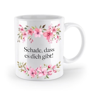 Könnte beinhalten: Weiße Keramiktasse mit einem rosafarbenen Blumendesign und dem Text "Schade, dass es dich gibt!" in Schwarz gedruckt.