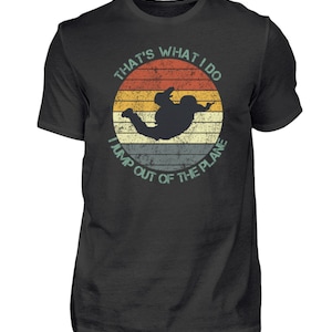 Könnte beinhalten: Ein schwarzes T-Shirt mit einer Grafik im Vintage-Stil eines Fallschirmspringers in einem Sonnenuntergang. Die Grafik lautet "That's what I do I jump out of the plane".
