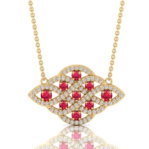 May include: A gold-colored pendant necklace featuring a decorative design with red gemstones and small white diamonds. The pendant is suspended from a delicate gold chain. The gemstones are oval-shaped.